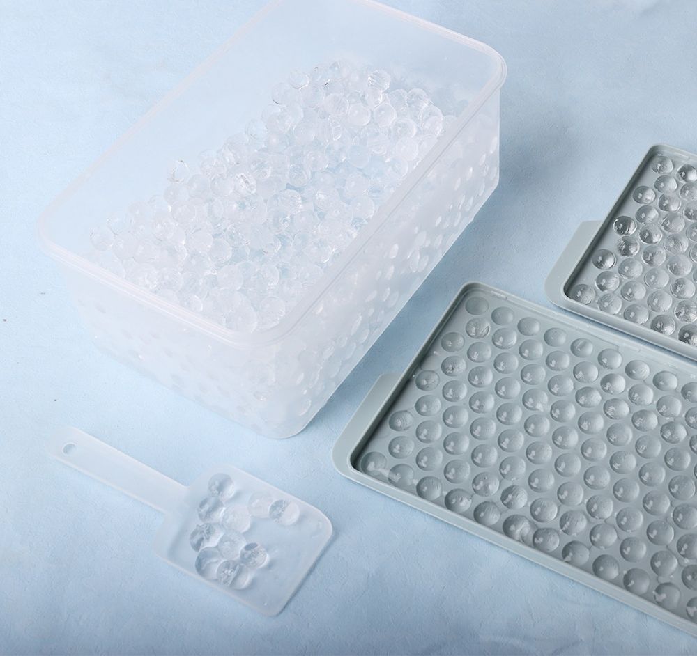 Round ice balls in the lidded storage bin with trays and scoop